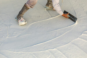 Worker Wearing Spiked Shoes Smoothing Wet Pool Plaster With Trowel.